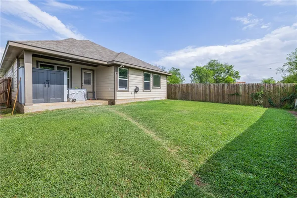 a front view of a house with a yard and trees