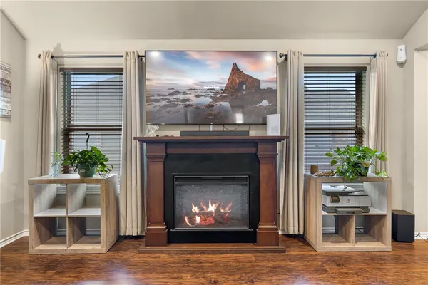 a living room with a fireplace and potted plants