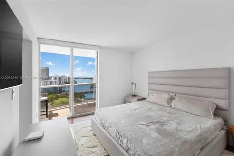 a bedroom with a large window and a bed