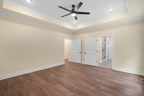 a view of an empty room with a window and wooden floor
