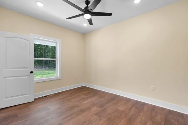 a view of a hallway with entryway and wooden floor