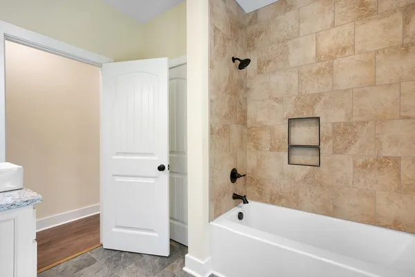 an empty room with wooden floor ceiling fan and windows