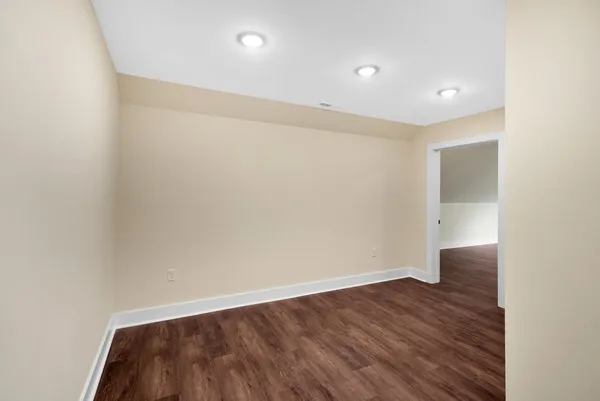an empty room with a window and wooden floor