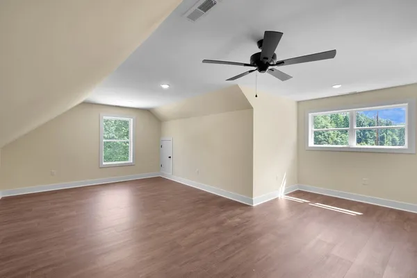 a view of a livingroom with wooden floor and a ceiling fan