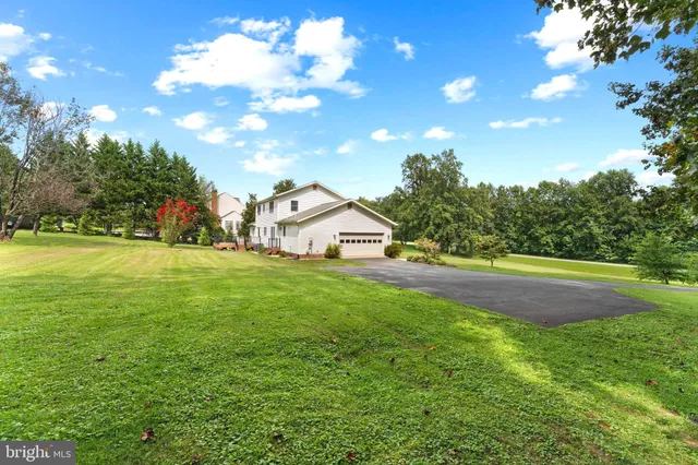 a view of a house with a wooden deck and a yard