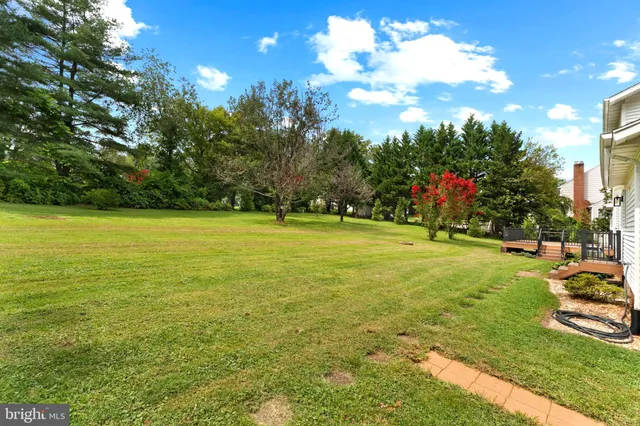 a view of a house with a big yard and sitting area