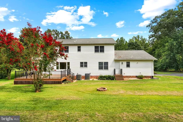 a view of a house with backyard and trees