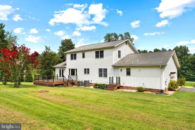 a view of a house with backyard and trees