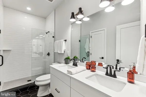 a bathroom with a sink a toilet and shower