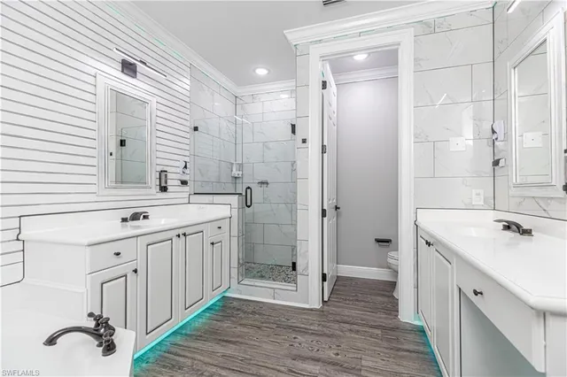 a spacious bathroom with a double vanity sink a mirror and a shower