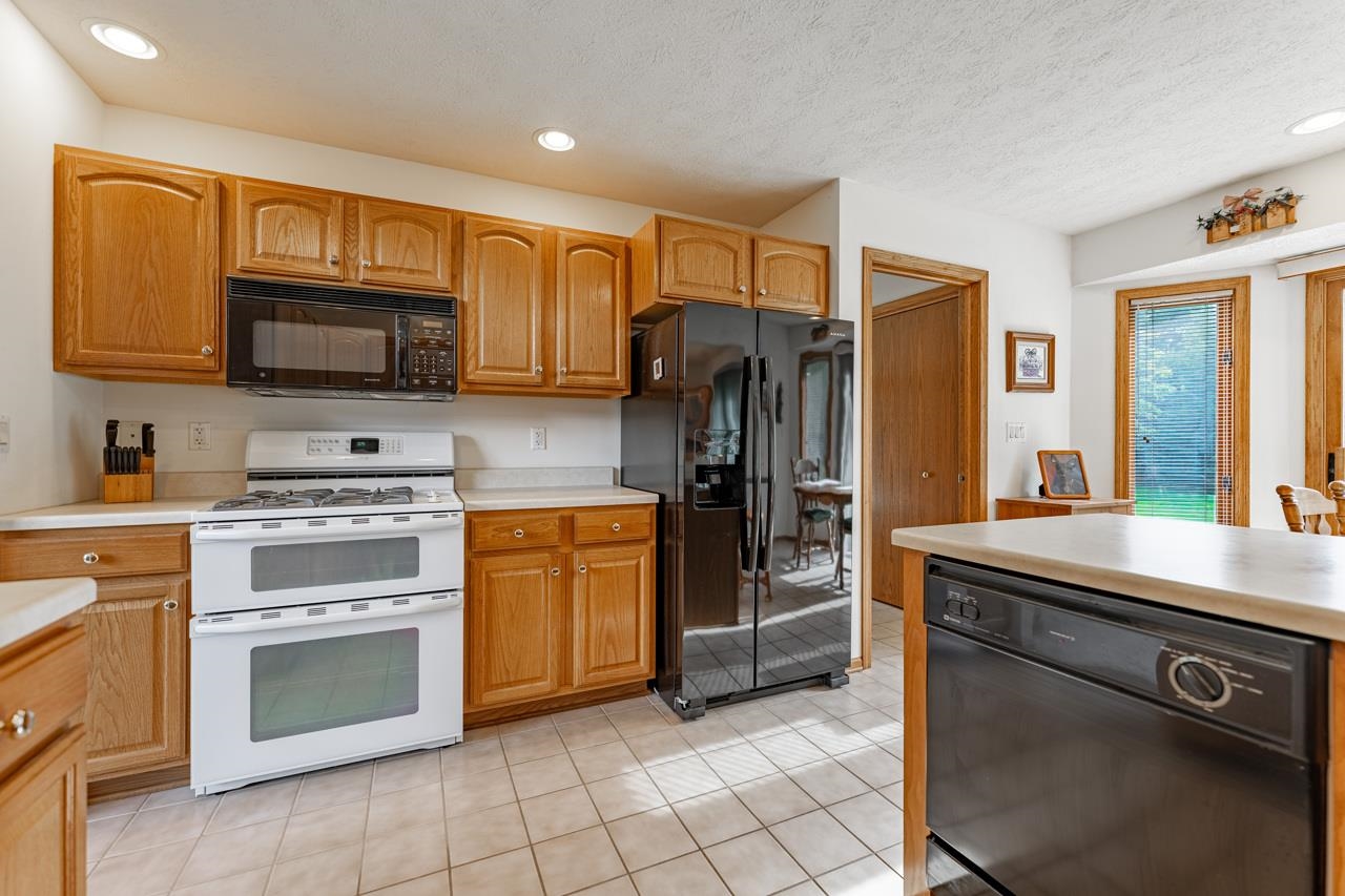625 Waco Way Poplar Grove, IL 61065 - Photo 12 of 34 a kitchen with stainless steel appliances granite countertop a refrigerator stove and sink