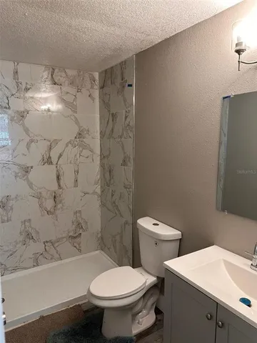 a white toilet sitting next to a bath tub