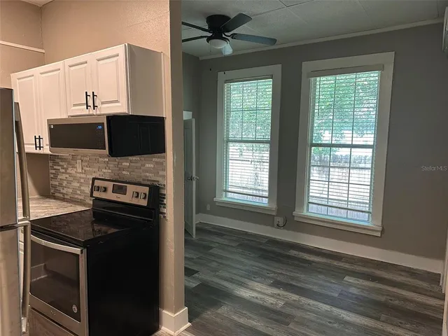 a kitchen with stainless steel appliances a stove microwave and refrigerator