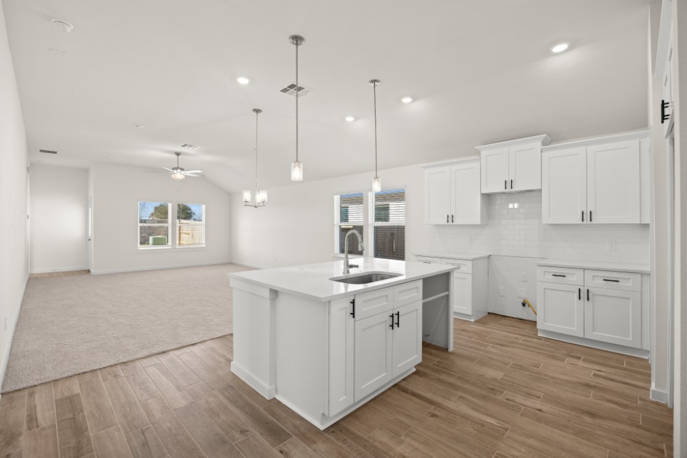 8311 Amber Summit Lane Angleton, TX 77515 - Photo 4 of 14 a kitchen with a sink stove cabinets and wooden floor