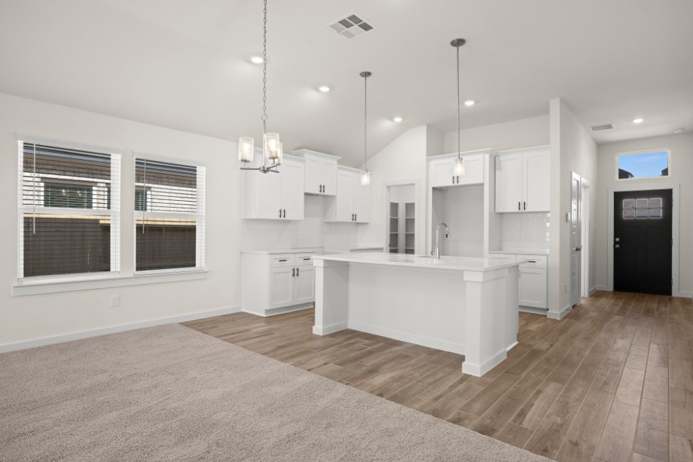 8311 Amber Summit Lane Angleton, TX 77515 - Photo 6 of 14 a large white kitchen with kitchen island a refrigerator a stove a sink dishwasher a oven with white cabinets and wooden floor