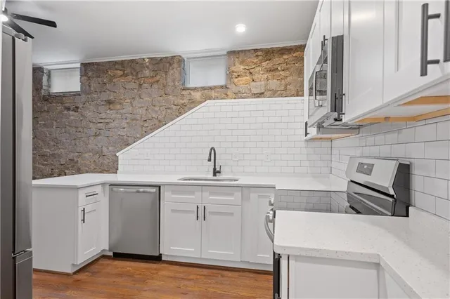 a view of a refrigerator in kitchen and an empty room