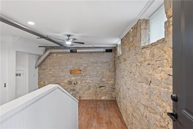 a view of hallway with wooden floor and cabinet