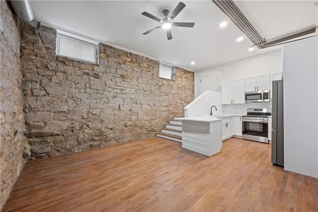 a kitchen with stainless steel appliances a stove sink microwave and cabinets