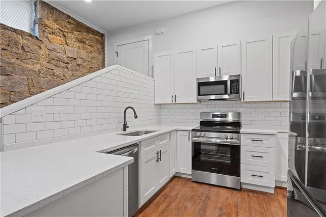 a kitchen with stainless steel appliances granite countertop a stove and a sink