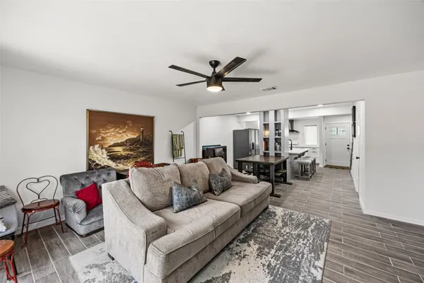 a living room with furniture a ceiling fan and a rug