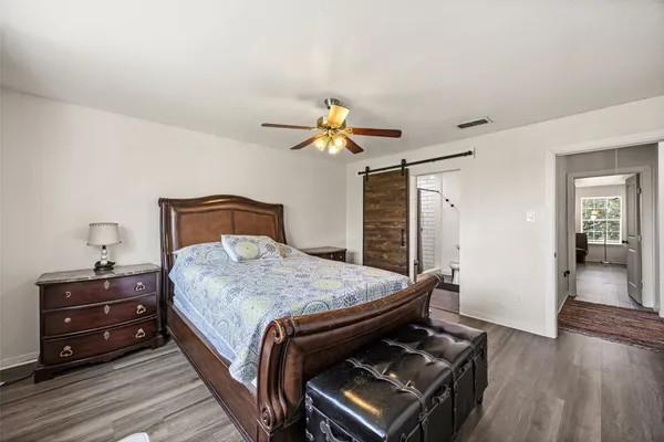 a bedroom with a bed and wooden floor