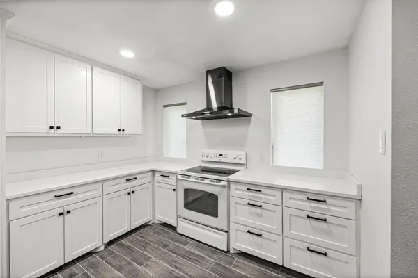 a kitchen with white cabinets and appliances
