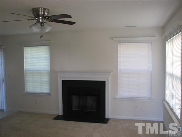 7317 Brighton Hill Lane Raleigh, NC 27616 - Photo 2 of 6 an empty room with windows and a fireplace