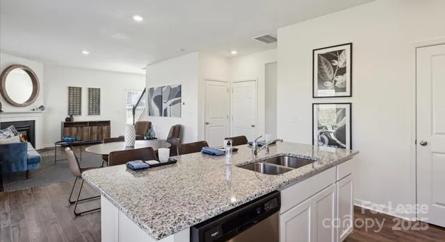 a kitchen with sink and living room