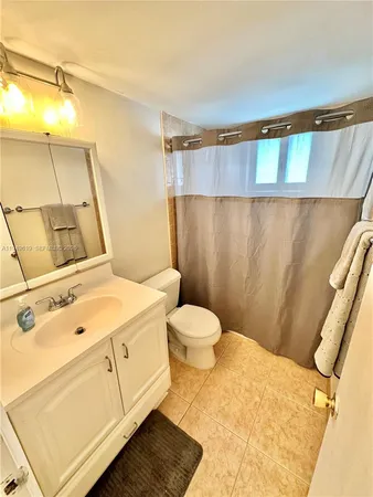 a bathroom with a sink a toilet a mirror and shower