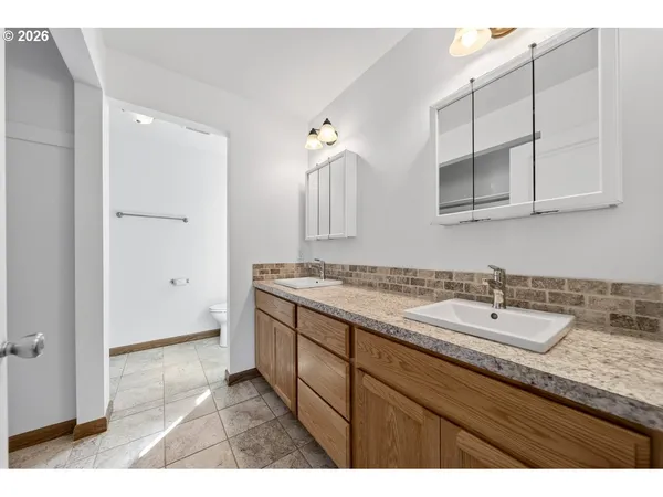 a bathroom with a granite countertop sink and a mirror