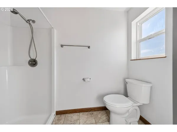 a bathroom with a toilet and a shower