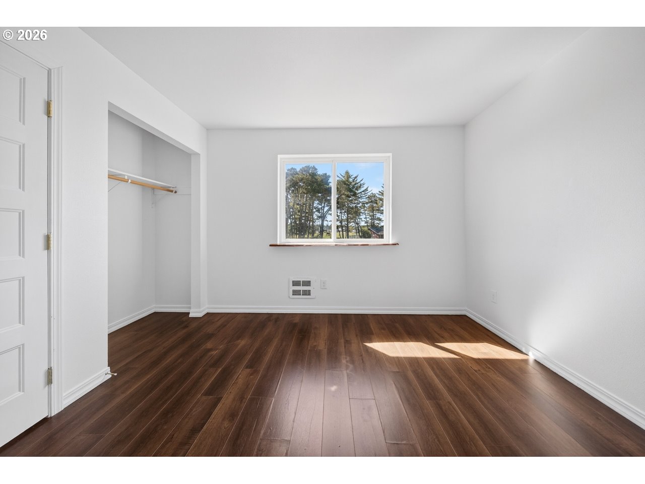 2679 Franklin Avenue Southwest Bandon, OR 97411 - Photo 30 of 48 a view of an empty room with wooden floor and a window