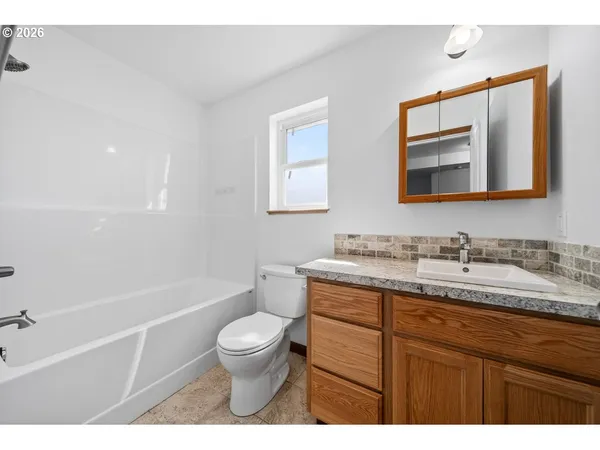 a bathroom with a granite countertop toilet sink and shower