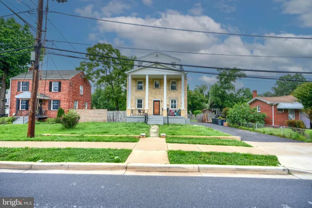 a front view of a house with a yard and potted plants