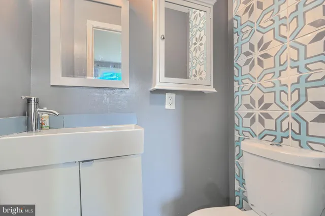 a bathroom with a sink a toilet and a mirror