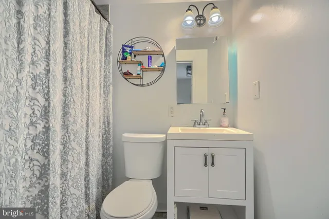 a bathroom with a toilet a sink and a mirror