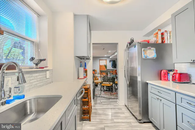 a kitchen with granite countertop lots of clutter and stainless steel appliances