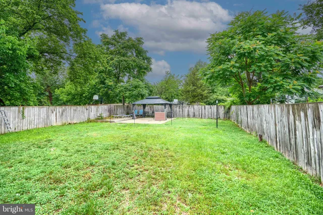 a view of a yard with a fence and trees