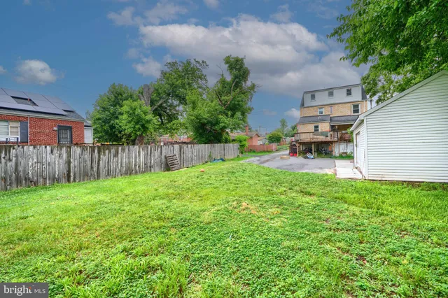 a view of a backyard with table and chairs and wooden fence