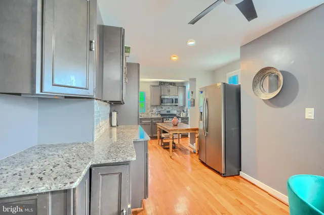 a kitchen with stainless steel appliances granite countertop a refrigerator and a stove top oven