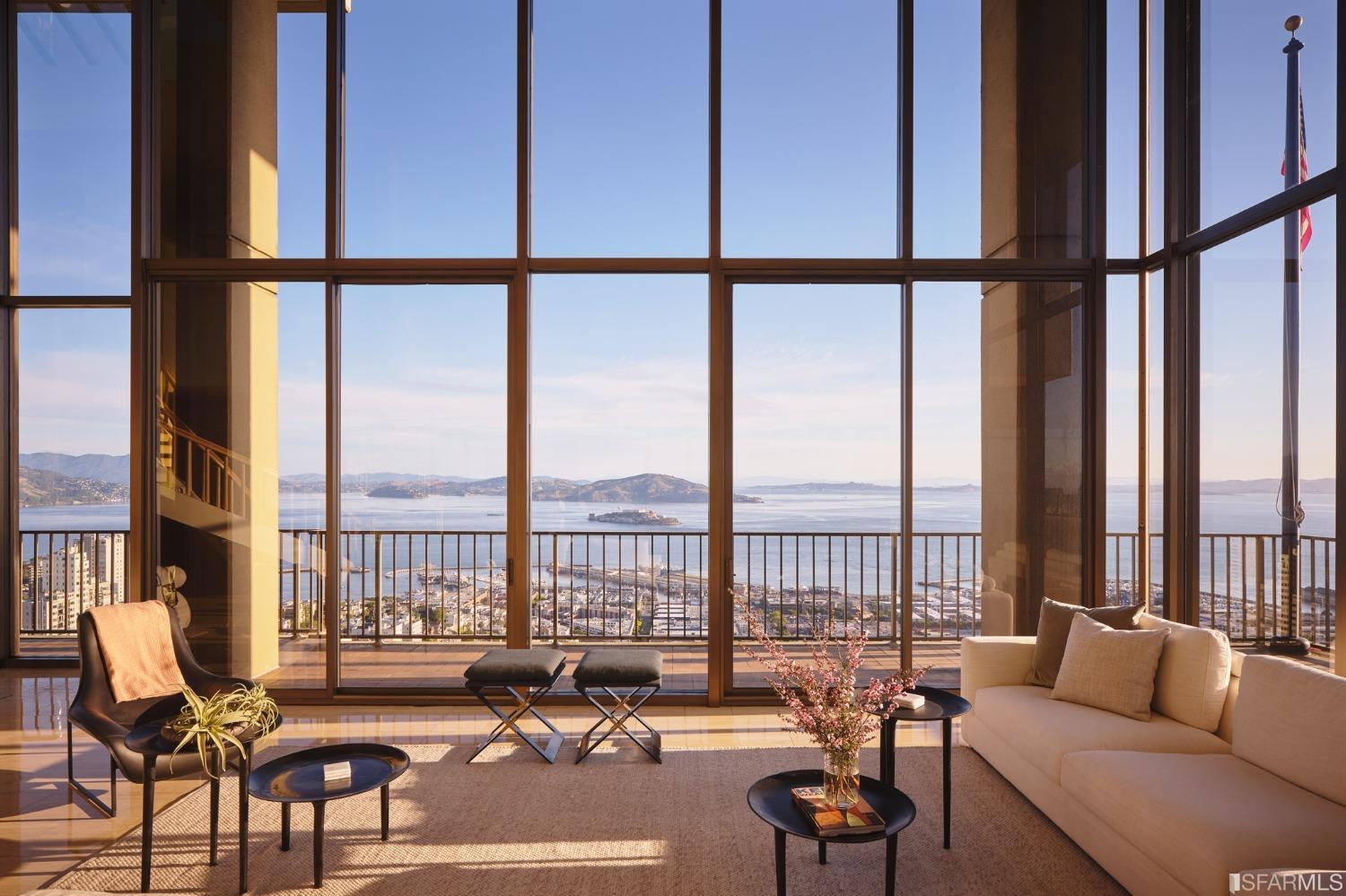 a living room with furniture and floor to ceiling windows