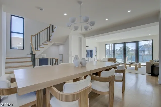 a very nice looking dining room with kitchen island furniture a large window and a chandelier