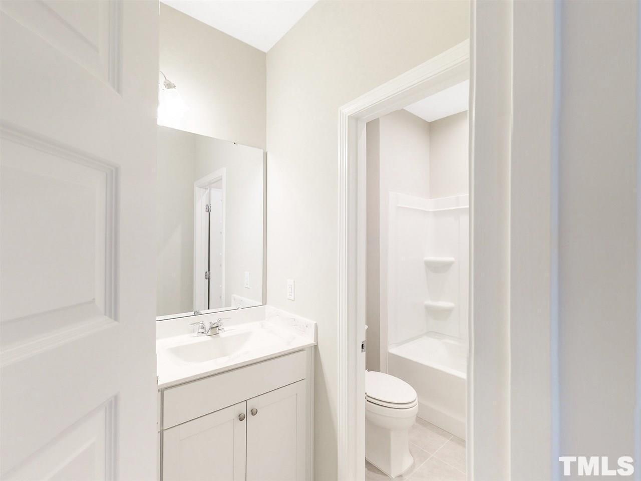 1605 Brussels Drive Apex, NC 27502 - Photo 12 of 17 a bathroom with a toilet a sink and a mirror