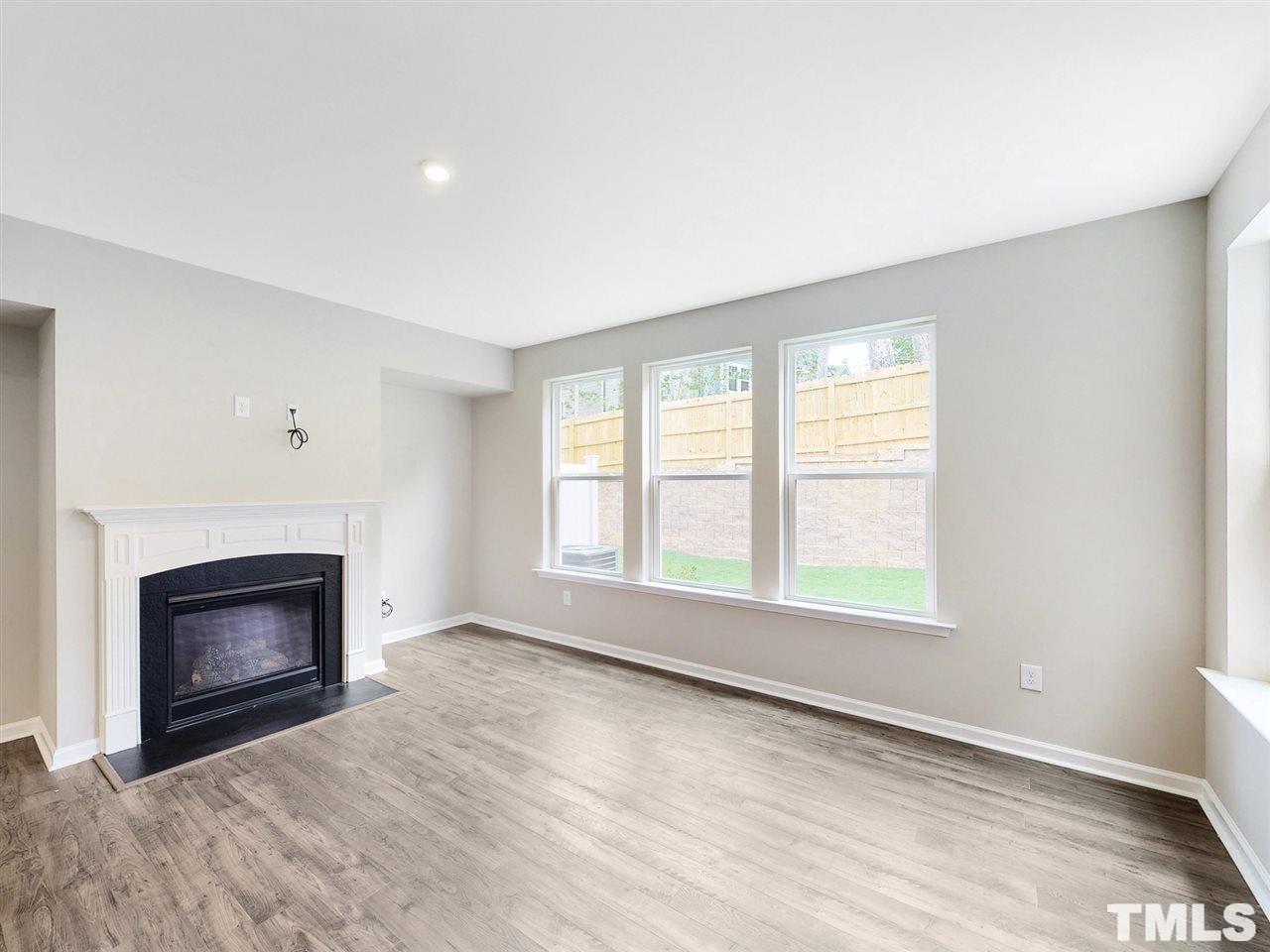 1605 Brussels Drive Apex, NC 27502 - Photo 5 of 17 an empty room with windows and fireplace