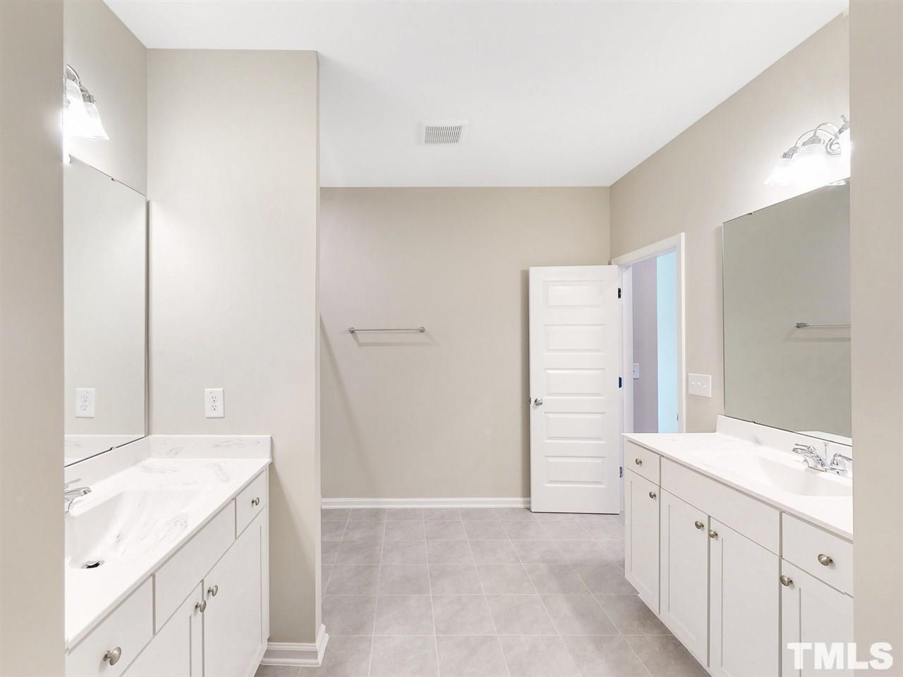 1605 Brussels Drive Apex, NC 27502 - Photo 9 of 17 a bathroom with a double vanity sink and mirror