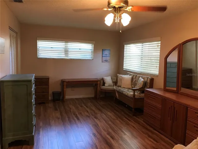 a living room with furniture a window and wooden floor