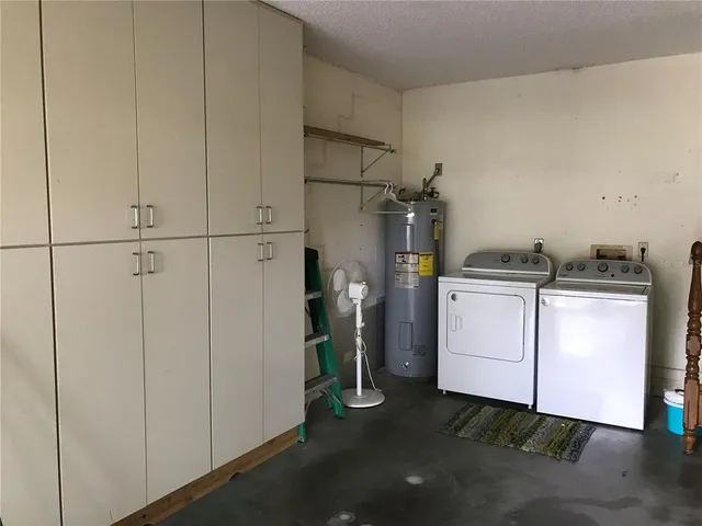 a utility room with cabinets washer and dryer