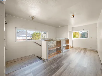 an empty room with wooden floor and window