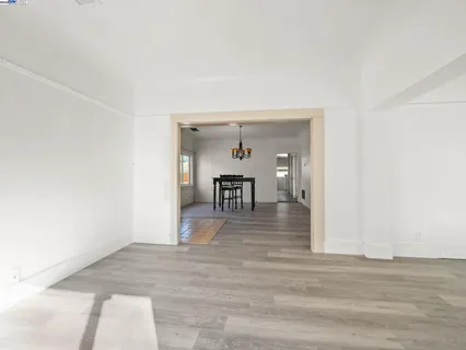 a view of a hallway with wooden floor and a living room