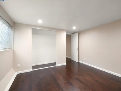 a view of an empty room with wooden floor